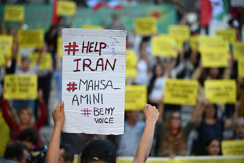 Protester hold up placards in Rome as they denounce the Iranian government after Amini's death. AFP