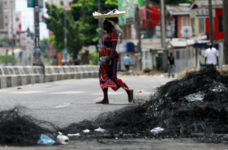 A woman walks past the remains of a burnt barricade in Surulere area of Lagos, Nigeria. Reuters