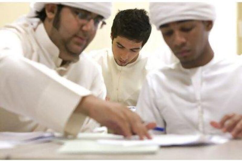 Abdallah Al Hosany, 18, centre, works on an English exercise while another student receives some assistance at Zayed University in Dubai.