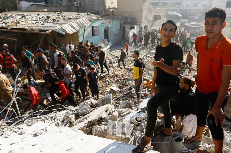 Palestinians gather at the site of Israeli strikes on a residential building in Khan Younis. Reuters