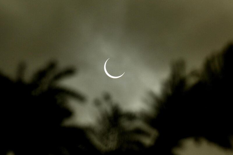 A solar eclipse is visible through cloud cover in Mysore, India. EPA