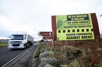 Traffic crosses the border into Northern Ireland from the Irish Republic alongside a Brexit Border poster on the Dublin road Co Armagh border, between Newry in Northern Ireland and Dundalk in the Irish Republic, on December 1, 2017,  
The European Union will not accept Britain's  Brexit offer if Ireland is not satisfied with proposals for future border arrangements, EU President Donald Tusk said in Dublin on December 1, 2017. / AFP PHOTO / Paul FAITH