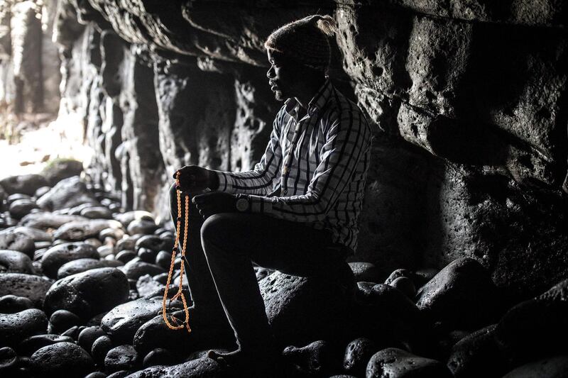This picture taken on March 23, 2020 shows a member of the Layenne community praying in the sacred Cave of Almadies, where the community's upcoming annual pilgrimage has been cancelled due to the COVID-19 novel coronavirus, in Dakar. / AFP / John WESSELS
