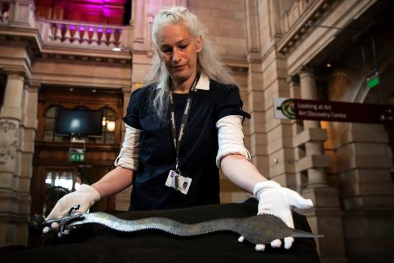 Museum conservator Stephanie De Roemer holds the Indo-Persian sword during the transfer of ownership ceremony at Kelvingrove Art Gallery and Museum in Glasgow. Getty Images