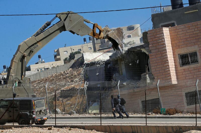 An Israeli army excavator machine demolishes a building in the Palestinian village of Sur Baher, in East Jerusalem.  Reuters