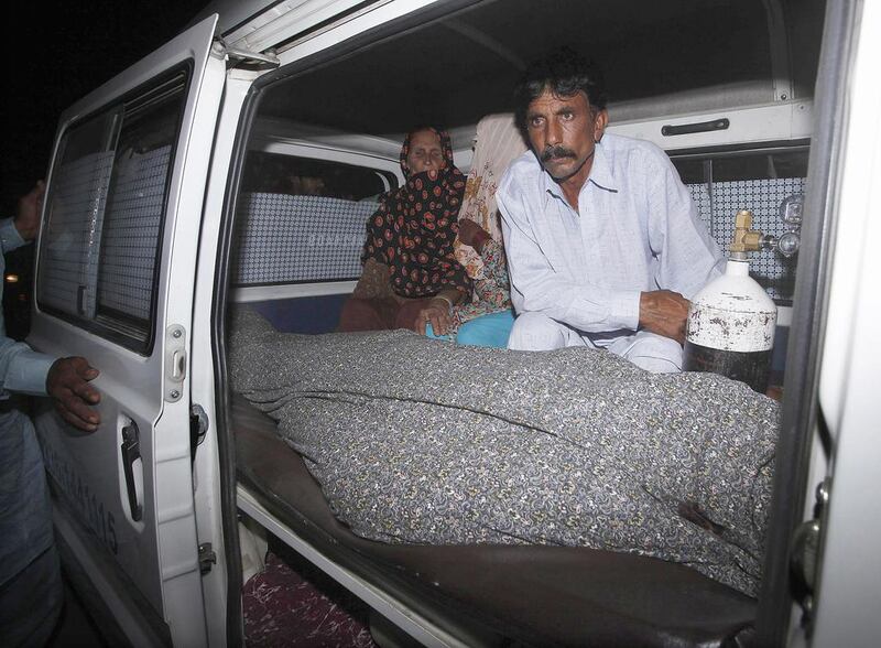 Mohammad Iqbal sits next to his wife Farzana's body. She was stoned to death by her family outside one of Pakistan's top courts in Lahore on May 27, 2014 in a so-called 'honour killing' for marrying the man she loved. Mohsin Raza/Reuters