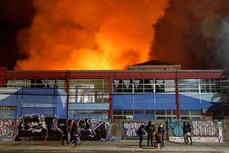 Smoke from a fire at a supermarket rises to the sky during a protest against the government in Valparaiso, Chile. Reuters