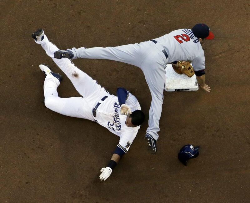 Minnesota Twins’ Brian Dozier (2) leaps over Milwaukee Brewers’ Carlos Gomez (27) at second to turn a double play on a ball hit by Khris Davis during the fourth inning of a baseball game in Milwaukee. Morry Gash / AP