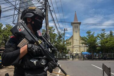 An Indonesian police officer stands guard outside a church after an explosion in Makassar on March 28, 2021. AFP 