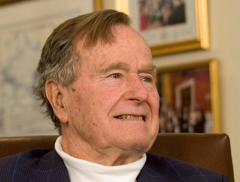FILE PHOTO -  Former President George H.W. Bush smiles as he listens to Republican presidential candidate Mitt Romney speak as he met with Bush to pick up his formal endorsement in Houston, Texas, U.S. March 29, 2012. REUTERS/Donna Carson/File Photo