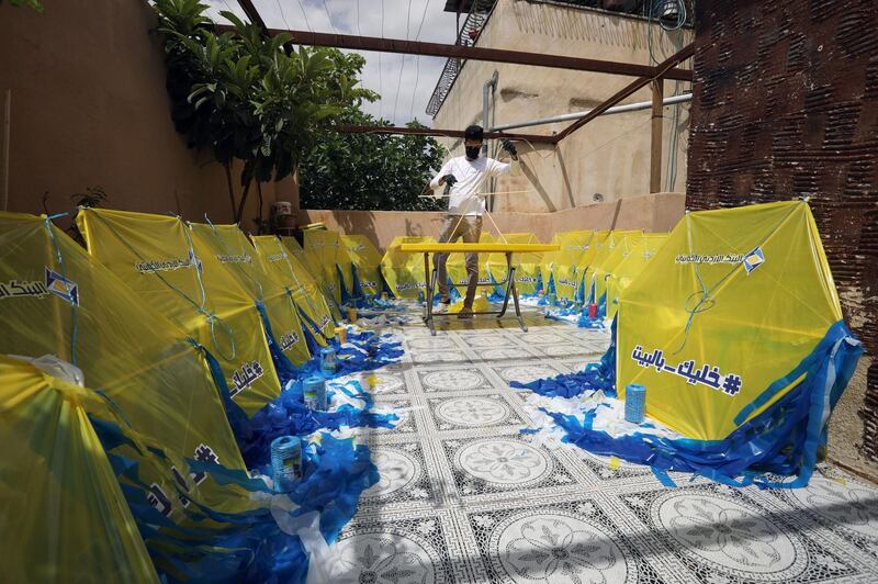 Kites with the phrase 'stay at home' are made as part of an initiative launched by Jordan Kuwait Bank to support some of the unemployed individuals and raise awareness against coronavirus, Amman, Jordan, April 19. Muhammad Hamed / Reuters