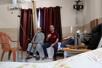 In this Tuesday, June 16, 2020 photo. Palestinian cancer patient Jehad al-Qedra, 52, and his relative Jabr, sit on the bed as they wait for their treatment at a hospital in Khan Younis refugee camp, Gaza Strip. The Palestinian Authority's decision to cut all ties with Israel was intended to make it pay a price for pressing ahead with plans to annex parts of the occupied West Bank. (AP Photo/Adel Hana)