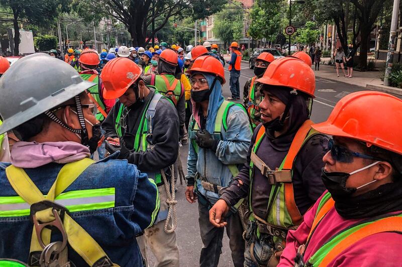 Construction workers gather in the street in Mexico City during a quake.    AFP