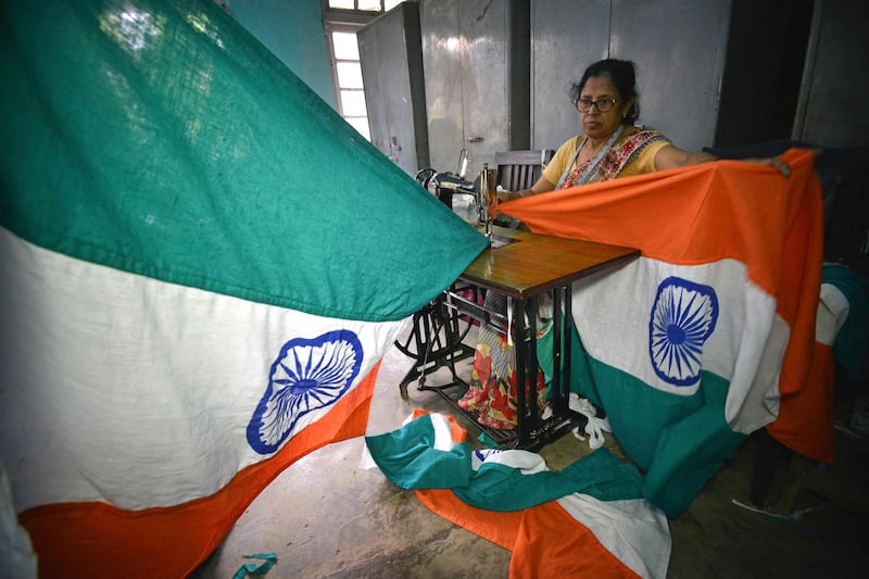 A woman stitches flags in Guwahati ahead of India's Independence Day celebrations. AFP