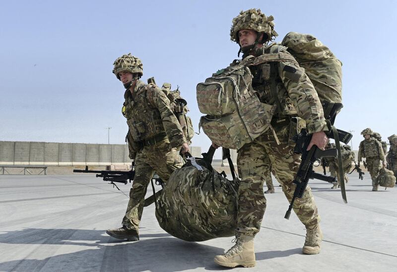 British soldiers walk with their gear after arriving in Kandahar on October 27, 2014, as British and US forces withdraw from the Camp Bastion-Leatherneck complex in Helmand province. British forces October 26 handed over formal control of their last base in Afghanistan to Afghan forces, ending combat operations in the country after 13 years which cost hundreds of lives. The Union Jack was lowered at Camp Bastion in the southern province of Helmand, while the Stars and Stripes came down at the adjacent Camp Leatherneck -- the last US Marine base in the country. AFP PHOTO/WAKIL KOHSAR (Photo by WAKIL KOHSAR / AFP)