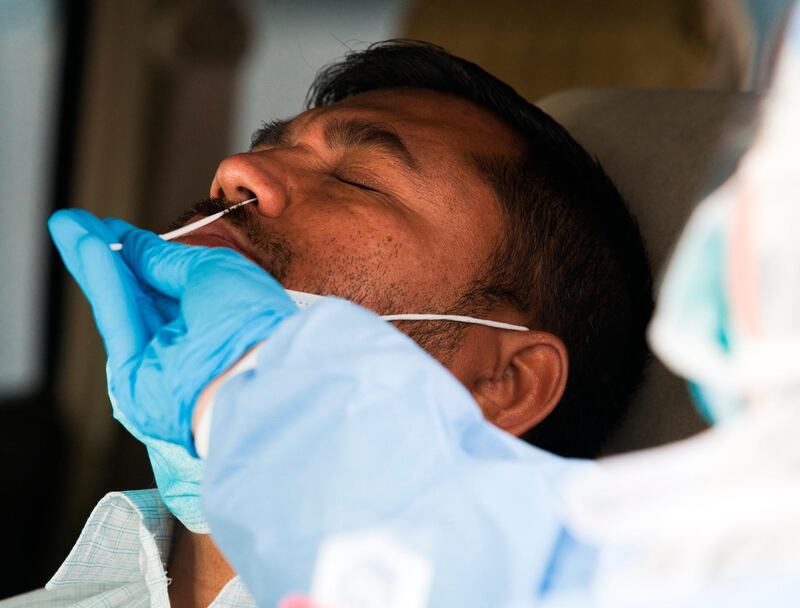 A technician takes a nasal swab.