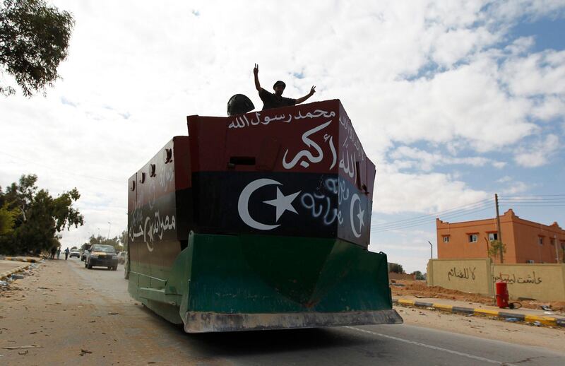 An anti-Gaddafi fighter flashes victory signs on an armored bulldozer during violent clashes with pro-Gaddafi forces at the frontline in center Sirte October 19, 2011.  REUTERS/Thaier al-Sudani (LIBYA - Tags: CONFLICT MILITARY CIVIL UNREST) *** Local Caption ***  LIB23_LIBYA-_1019_11.JPG