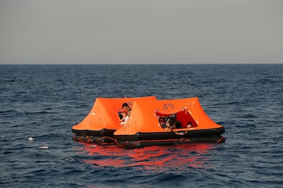 Afghan migrants watch from inside a life raft during a rescue operation by the Turkish coast guard, in the Aegean Sea, between Turkey and Greece, Saturday, Sept. 12, 2020. Turkey is accusing Greece of large-scale pushbacks at sea â€” summary deportations without access to asylum procedures, in violation of international law. The Turkish coast guard says it rescued over 300 migrants "pushed back by Greek elements to Turkish waters" this month alone. Greece denies the allegations and accuses Ankara of weaponizing migrants. (AP Photo/Emrah Gurel)