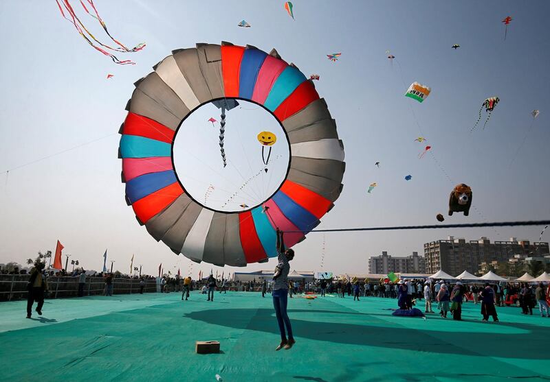 A kite-flying enthusiast hangs onto a rope as she tries to pull down a ring kite on the first day of the eight-day-long International Kite Festival in Ahmedabad, India. Amit Dave / Reuters