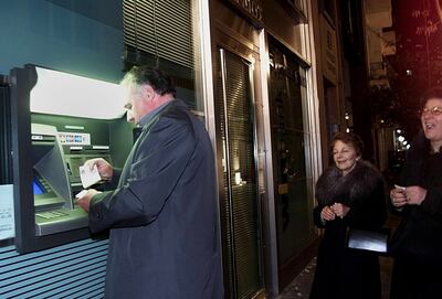 A man gets the first euro banknotes from an ATM bank machine a few minutes after midnight on January 1, 2002. EPA