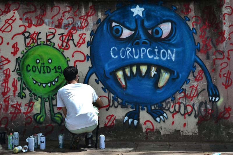 A street artist paints a mural about Covid-19 and corruption, in the surroundings of the Hospital Escuela in Tegucigalpa, Honduras. AFP
