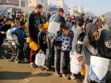 Palestinians queue as they wait to collect drinking water in the southern Gaza Strip January 4, 2024. Reuters