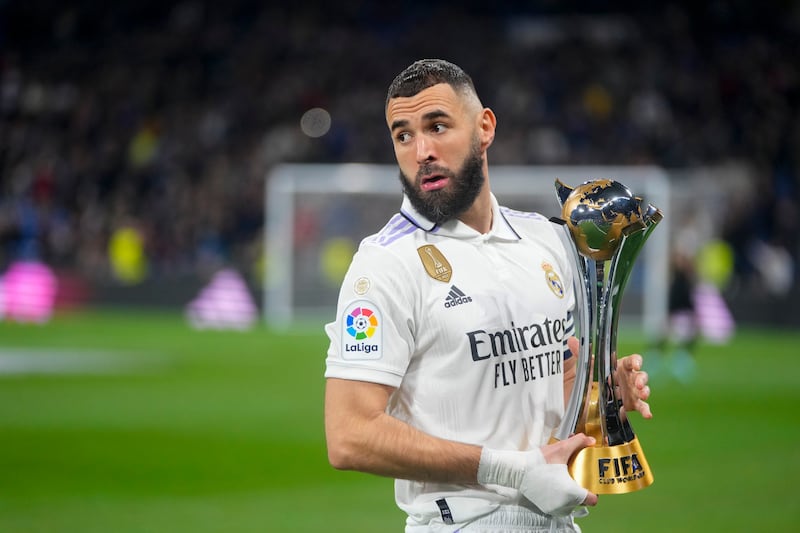 Real Madrid's Karim Benzema holds up the FIFA Club World Cup trophy prior to a Spanish La Liga soccer match between Real Madrid and Elche CF at the Santiago Bernabeu stadium in Madrid, Spain, Wednesday, Feb.  15, 2023.  (AP Photo / Manu Fernandez)