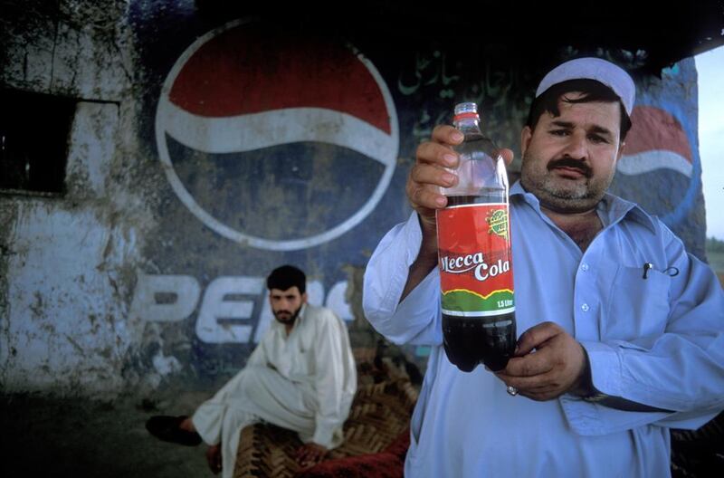 A restaurant owner in Afghanistan holds up a bottle of Mecca Cola. Customers increasingly want to exercise the power of the money in their pockets. Photo by Reza / Getty Images