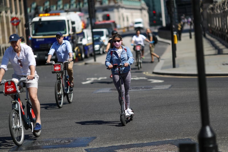 Cyclists and an electric scooter rider navigate a junction in London, U.K., on Thursday, May 21, 2020. The government in London is trying to reboot the economy while also extending a stay-at-home pay program. Photographer: Simon Dawson/Bloomberg via Getty Images