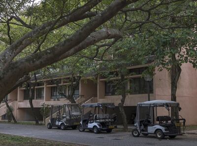Golf carts stand parked in front of a low-rise building in Discovery Bay, a residential project developed by Hong Kong Resort Co., on Lantau Island in Hong Kong, China, on Tuesday, March 27, 2018. As carmakers race to sell glitzy new models to wealthy Chinese, the old-fashioned golf cart is the hottest buy in one corner of Hong Kong, with prices topping those of a Tesla Model S and Porsche's Boxster sports cars. Photographer: Justin Chin/Bloomberg