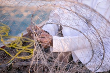 A man prepares a soon-to-be banned gargoor net for fishing. Reem Mohammed / The National 