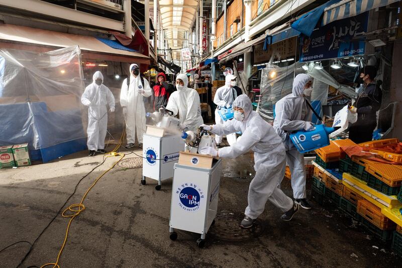 Workers spray disinfectant as a precaution against covid-19 at Saemaeul traditional market in Seoul, South Korea.  EPA