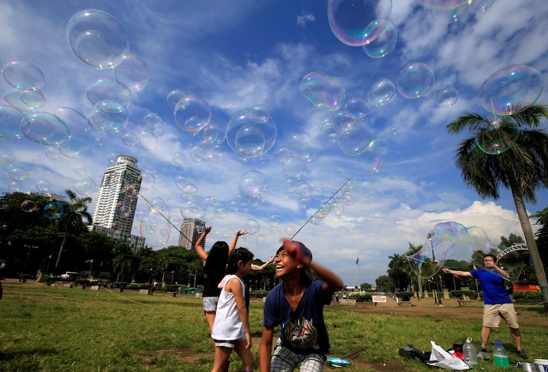 Children play with soap bubbles created by a street performer at Rizal Park in Manila, Philippines, on May 16, 2018. Romeo Ranoco / Reuters