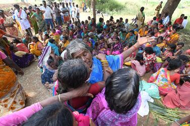 Indian women mourn the death of relatives in a case of food poisoning at Bidarahalli, near Sulawadi village in Chamarajnagar district of Karnataka state, India, Saturday, Dec. 15, 2018. Police on Saturday arrested three people after at least 10 died of suspected food poisoning following a ceremony to celebrate the construction of a new Hindu temple in southern India. (AP Photo/Madhusudhan Sr)