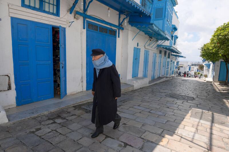 A Tunisia man walks in front of closed shops in the village of Sidi Bou Said,  20 kilometres northeast of Tunis, during the general confinement imposed to stem the spread of the novel coronavirus.  AFP