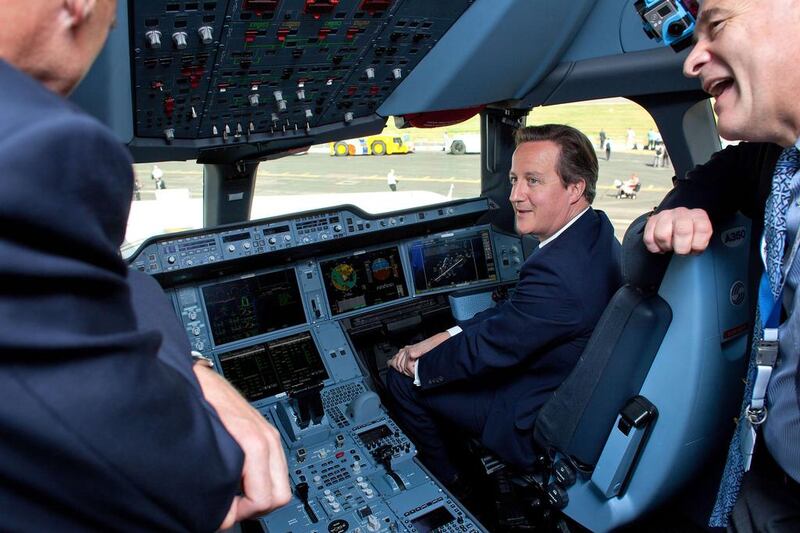 British prime minister David Cameron, second right, sits in the cockpit of an Airbus A350 aircraft on the first day of the Farnborough International Airshow. Ben Gurr / AFP