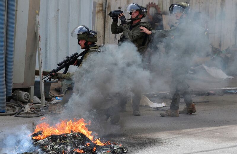 Israeli soldiers take positions during clashes with Palestinians in THE village of Azzun in the occupied West Bank after the funeral of Yahya Adwan, who was killed during an Israeli army operation. AFP