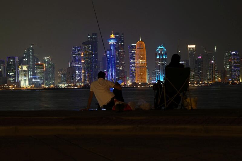 A family sit at Corniche as they look at skyscrapers night scene at Al Dafna Area in Doha, Qatar, October 20, 2019. Picture taken October 20, 2019. REUTERS/Naseem Zeitoon