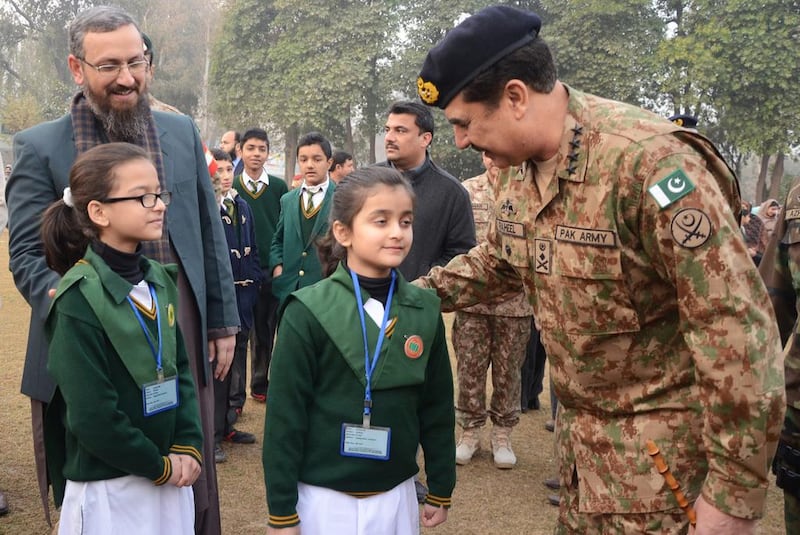 Pakistani Army chief Raheel Sharif, right, speaks with students at the Army Public School after it was reopened. AFP Photo