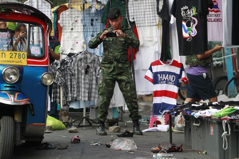 A soldier photographs the scene of an explosion on February 23, 2014, at an anti-government protest site in Bangkok, Thailand. More than a dozen people were hurt in the explosion less than a day after a bloodier attack in an eastern province killed one child and left about three dozen people wounded. Wally Santana / AP photo