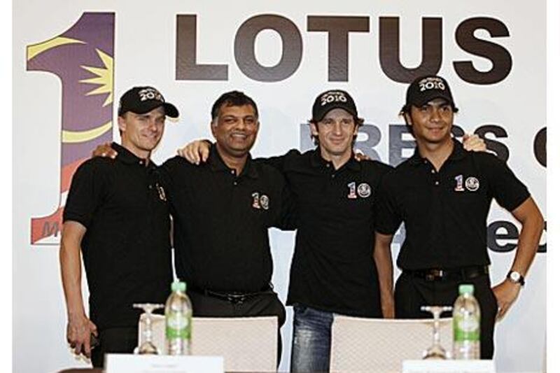 Jarno Trulli, second right, Heikki Kovalainen, left, and Malaysia's Fairuz Fauzy, right, pose with the Lotus F1 racing team principal Tony Fernandes at a press conference in Kuala Lumpur.