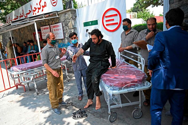 A wounded Afghan man prepares to stand from a stretcher after he received treatment at an Italian aid organisation hospital, following the rocket attack in Kabul. AFP