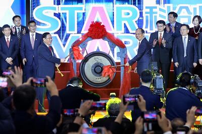 Li Qiang, center left, Shanghai's Party chief, and Yi Huiman, center right, chairman at China Securities Regulatory Commission, strikes a gong to launch the SSE STAR Market in the hall of Shanghai Securities Exchange in Shanghai, China, Monday, July 22, 2019. Trading started Monday on a Chinese stock market for high-tech companies that play a key role in official development plans that are straining relations with Washington. (Chinatopix via AP)