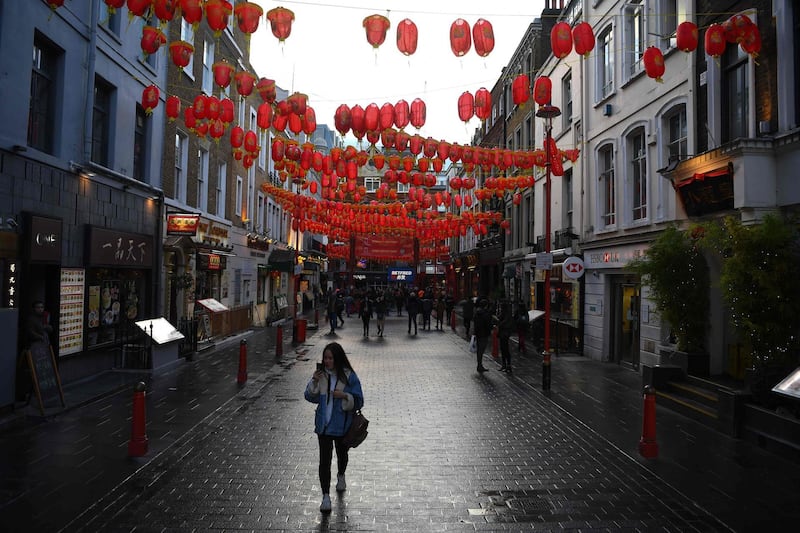 (FILES) This file photo taken on February 13, 2020 shows visitors walking under Lunar New Year decorations in London's Chinatown district. Bustling century-old Chinatowns from Melbourne to San Francisco have fallen quiet and businesses are struggling to survive as fears over the deadly novel coronavirus outbreak ripple around the world. - TO GO WITH Australia-China-virus-health-economy,FOCUS by Sean GLEESON
 / AFP / DANIEL LEAL-OLIVAS / TO GO WITH Australia-China-virus-health-economy,FOCUS by Sean GLEESON
