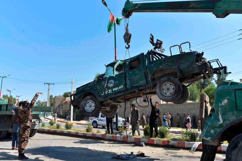 Afghan security forces removes a damaged police vehicle at the site of a car bomb attack that targeted Laghman provincial governor's convoy, in Mihtarlam, Laghman Province on October 5, 2020. A suicide attack targeting an Afghan provincial governor killed at least eight people on October 5, officials said, as the president travelled to Qatar where peace talks with the Taliban have stalled.  / AFP / NOORULLAH SHIRZADA
