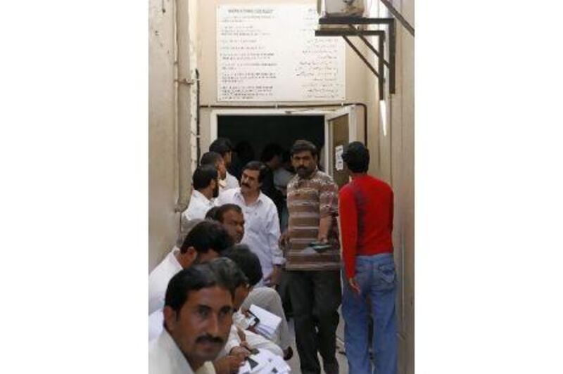 People queue up to secure their Machine Readable Passports at the Pakistani consulate in Dubai. Jeffrey E Biteng / The National