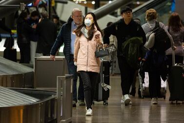 A traveller wearing a face mask walks inside the Seattle-Tacoma International Airport (SEA) in Seattle, Washington. Shares of long-haul flight operators Air France, Lufthansa and British Airways-owner IAG retreated, as news of the latest viral lung illness contagion raised concerns among investors. Bloomberg