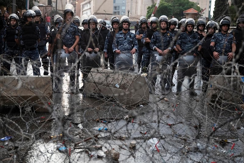 Riot police stand guard behind barbed-wire next to the Government Palace in downtown Beirut. Reuters