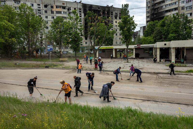 Public transit workers sweep up shrapnel in Kharkiv, Ukraine. Getty Images