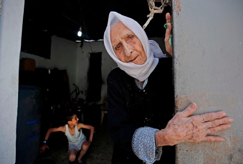 A Palestinian refugee elderly woman, who witnessed the 1948 Nakba, looks out of her house's entrance door at Al-Shati refugee camp in Gaza City, as Palestinians marked the 72nd anniversary of "Nakba" (Day of Catastrophe) inside their homes due to the COVID-19 coronavirus pandemic.  The "Nakba" commemorates the mass displacement of more than 700,000 Palestinians who fled or were expelled from their homes in the 1948 war surrounding Israel's creation.  AFP